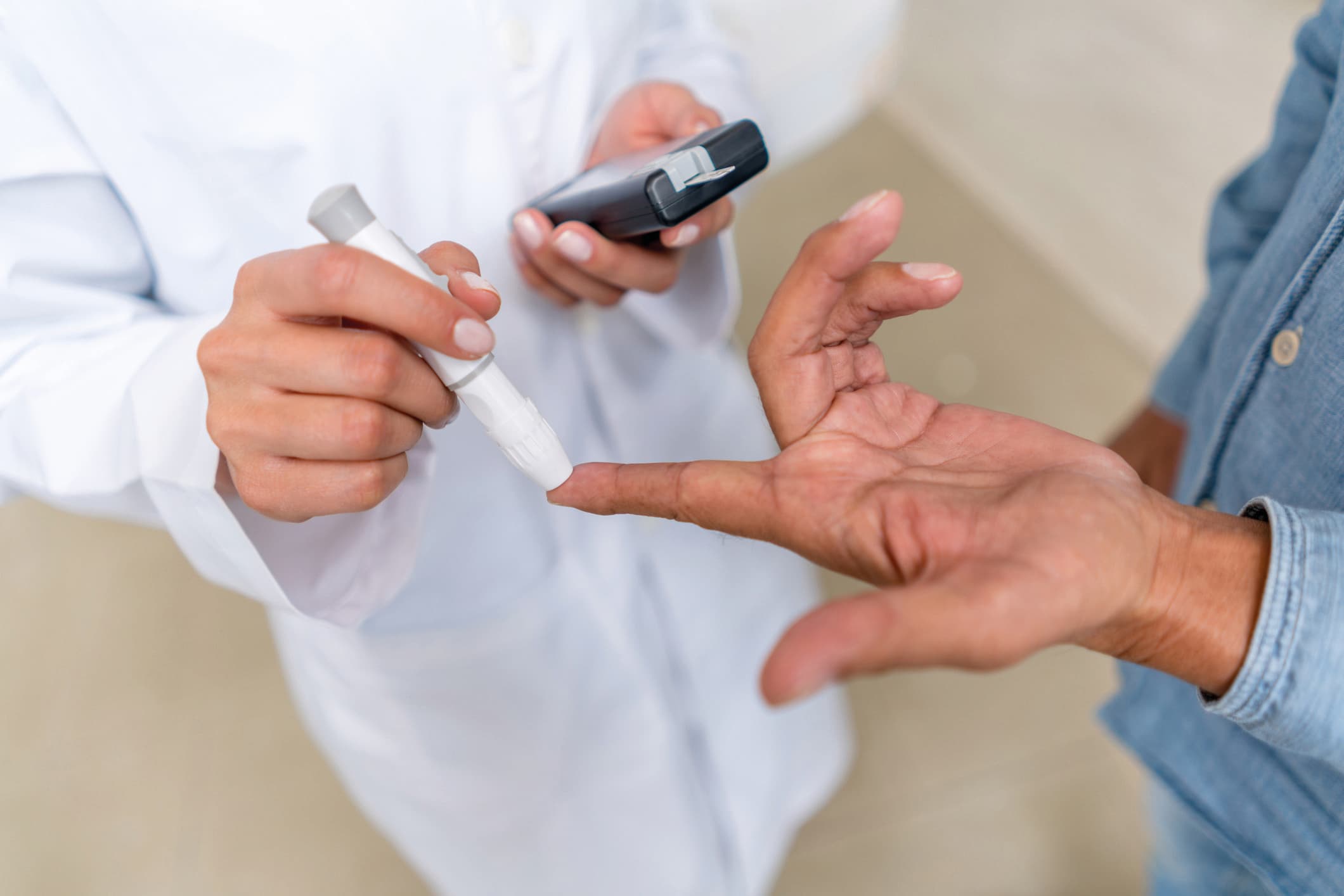 Mann überprüft Zuckerspiegel mit Glucometer anhand einer Blutprobe