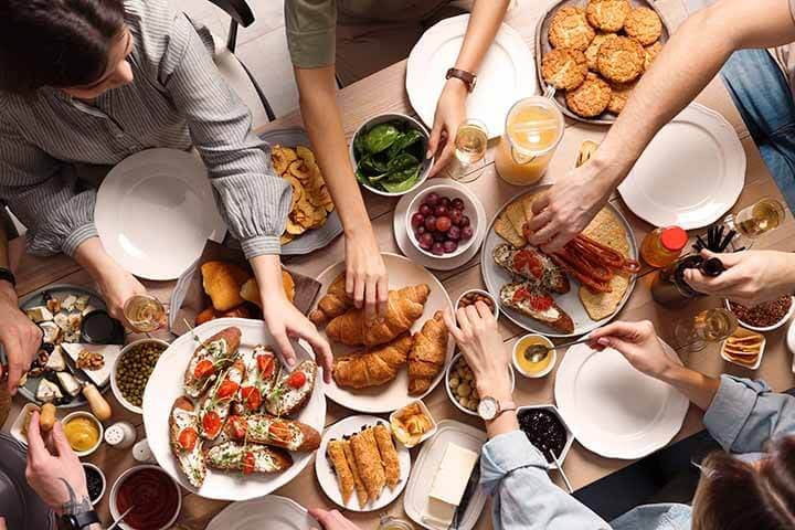 Group of people having brunch together at table, top view