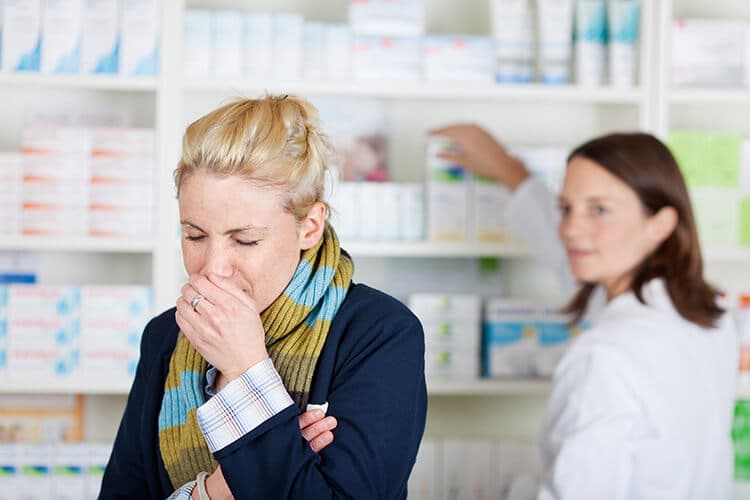 Erkältete Frau in Apotheke